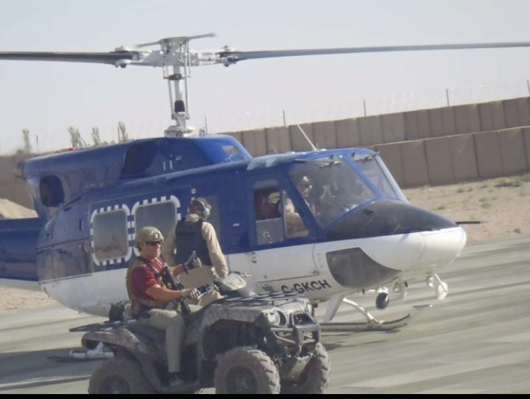 John Siver II riding a quad near a helicopter